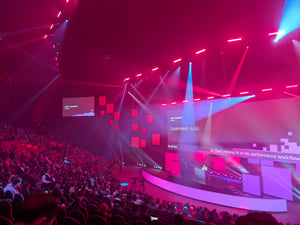 Audience attending the AWS Sydney Summit 2026 inside a large auditorium with illuminated stage screens showcasing AI and cloud technology presentations.
